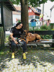 Hund und Frauchen sitzen beim Social Walk auf einer Bank